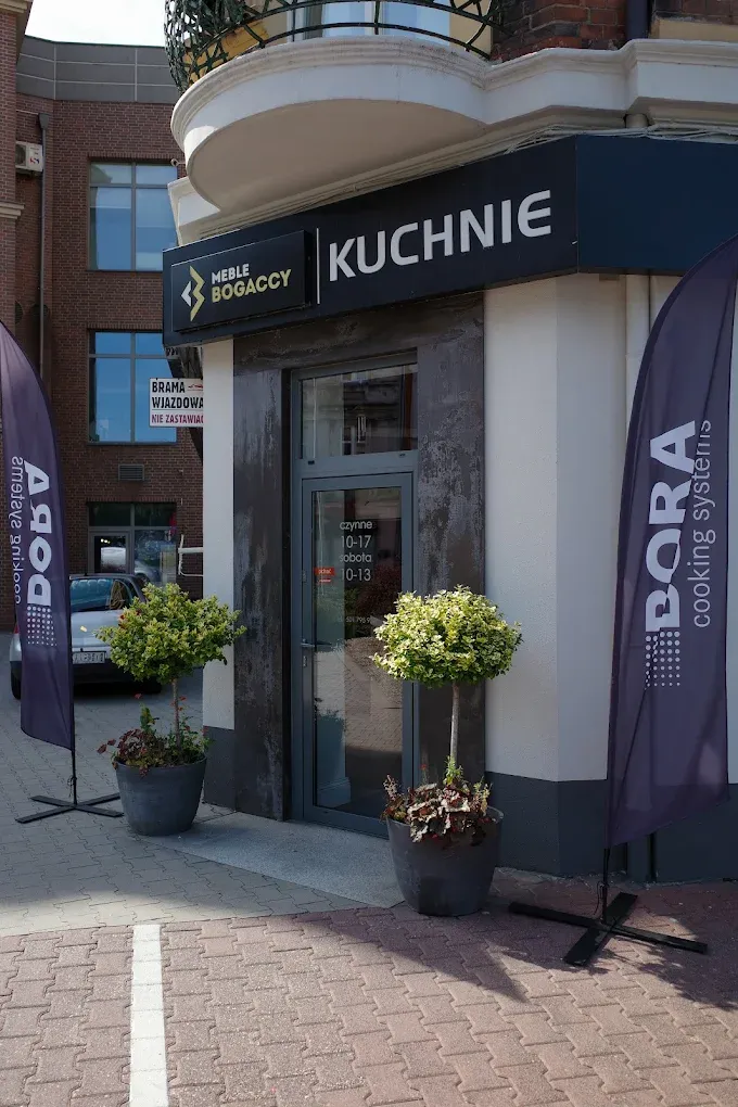 Wejście do salonu Bogaccy z szyldem Kuchnie